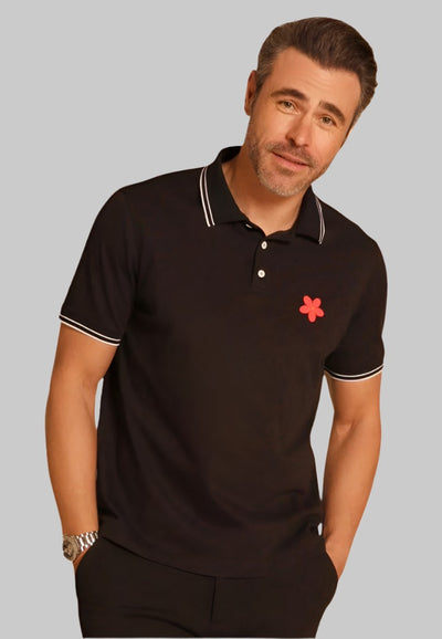 Made in Thailand, this Buki "happy" polo shirt features a "happy" flower motif on the chest. In Black.