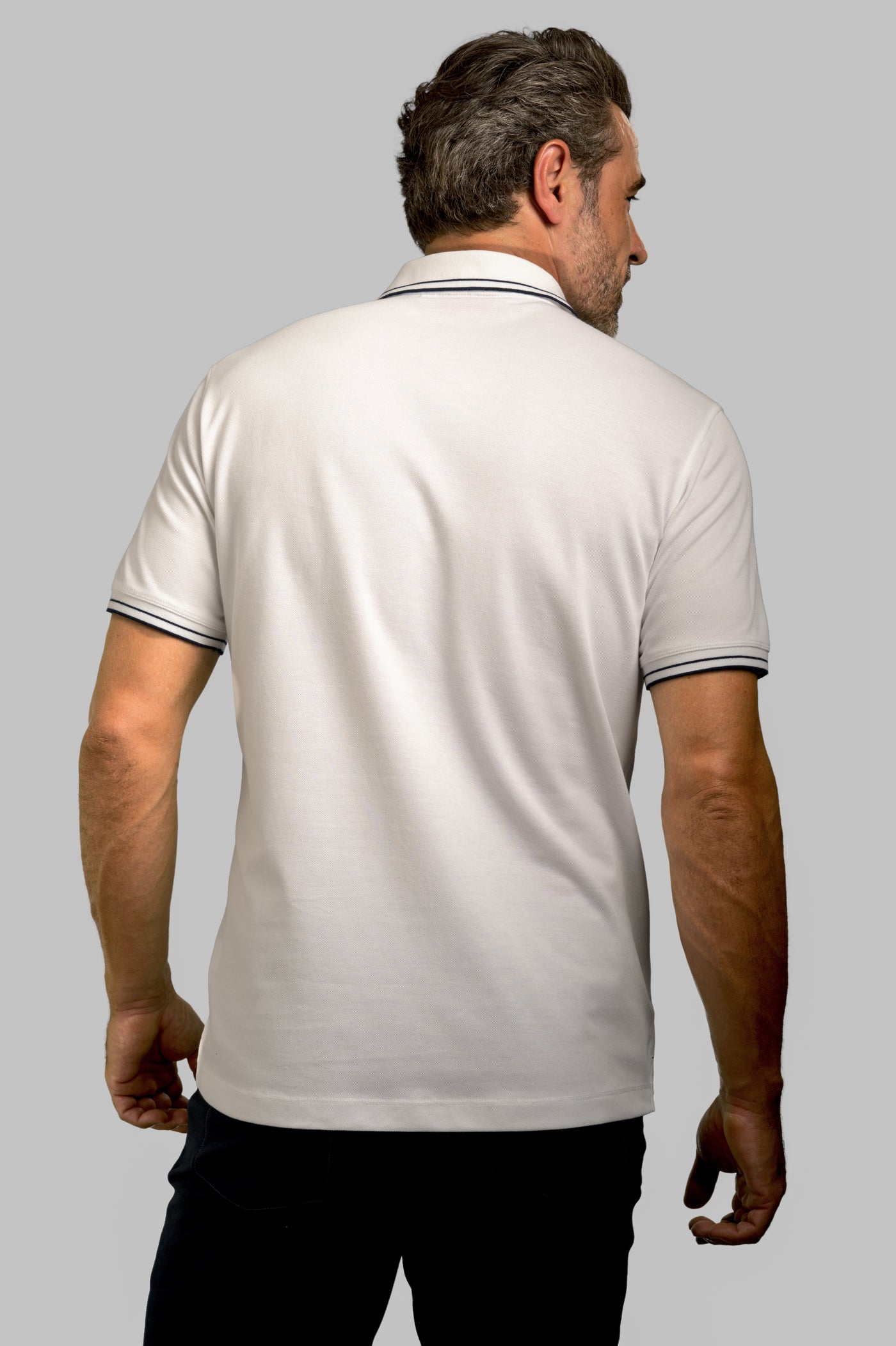 Made in Thailand, this Buki "happy" polo shirt features a "happy" flower motif on the chest. In White.